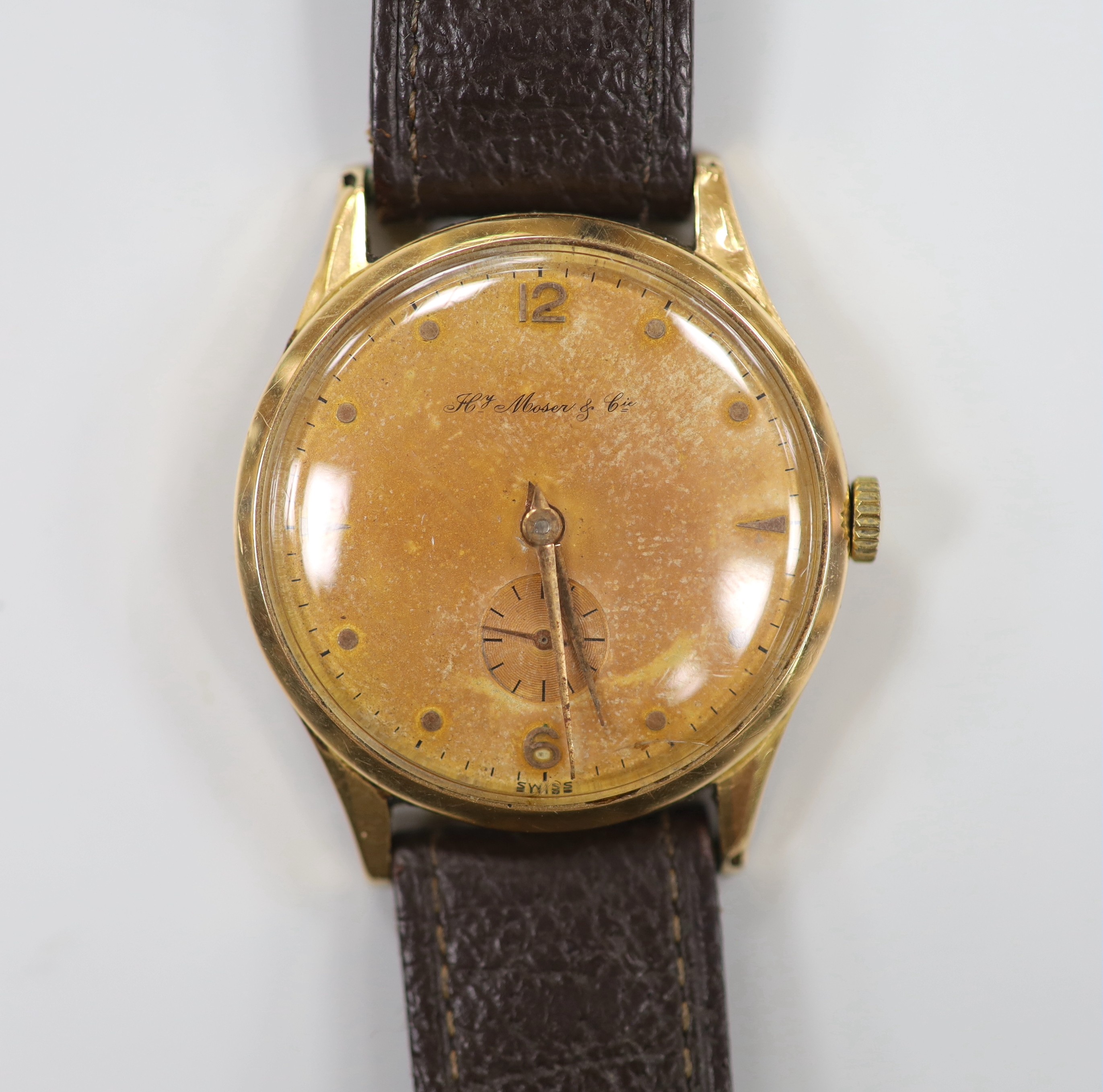 A gentleman's 1950's? 18k manual wind wrist watch, retailed by H. Moser & Cie, with subsidiary seconds, case diameter 36mm, on leather strap, gross weight 37.7 grams.